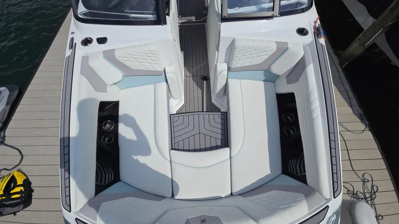 Slide: The Image of 2022 Correct Craft Super Air Nautique G23 boat interior with white seating and sleek design. - 23