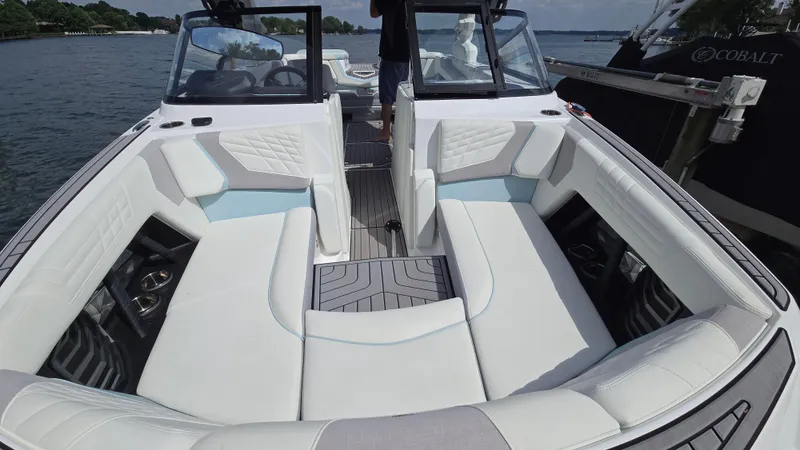 Slide: The Image of 2022 Correct Craft Super Air Nautique G23 boat interior with white seating and open water view. - 24