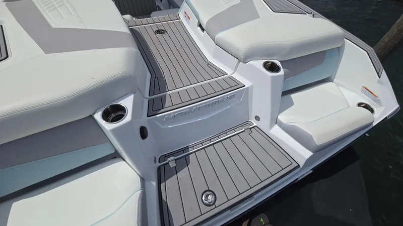 Slide: The Image of 2022 Correct Craft Super Air Nautique G23 boat interior with gray and white seating and cup holders. - 30