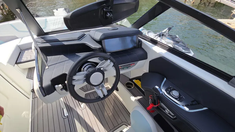 Slide: The Image of 2022 Correct Craft Super Air Nautique G23 dashboard with modern steering and touchscreen display. - 40