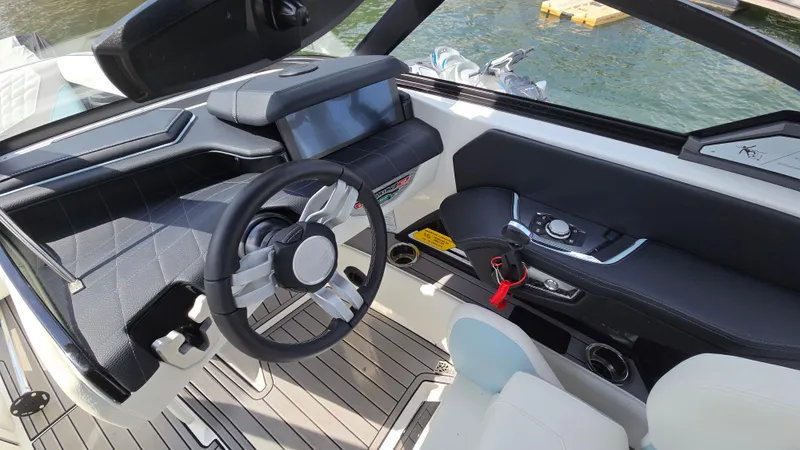 Slide: The Image of 2022 Correct Craft Super Air Nautique G23 boat interior with modern steering and controls. - 41
