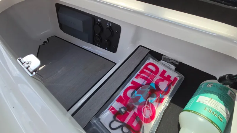 Slide: The Image of Storage compartment in 2022 Correct Craft Super Air Nautique G23 with Liquid Force gear and fire extinguisher. - 46