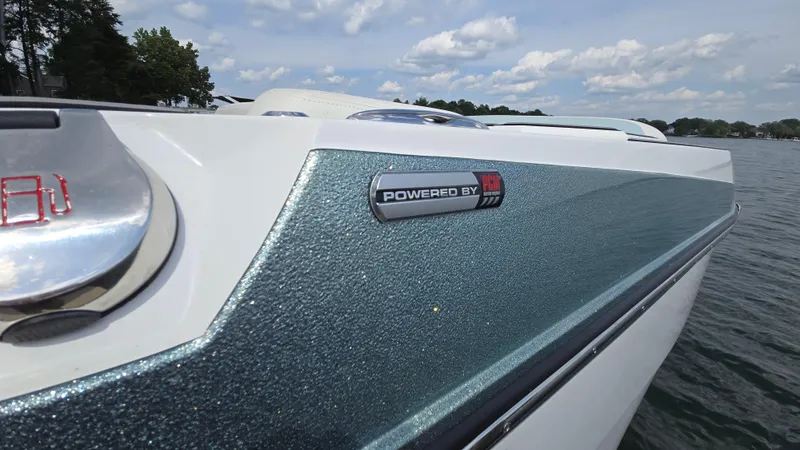 Slide: The Image of 2022 Correct Craft Super Air Nautique G23 boat on water, close-up of hull and logo. - 6