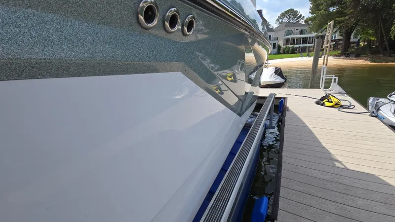 Slide: The Image of 2022 Correct Craft Super Air Nautique G23 docked, showcasing sleek design and detailing. - 7