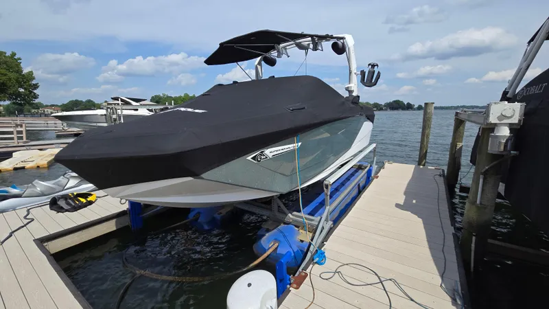 Slide: The Image of 2022 Correct Craft Super Air Nautique G23 boat covered and docked by a lake. - 9