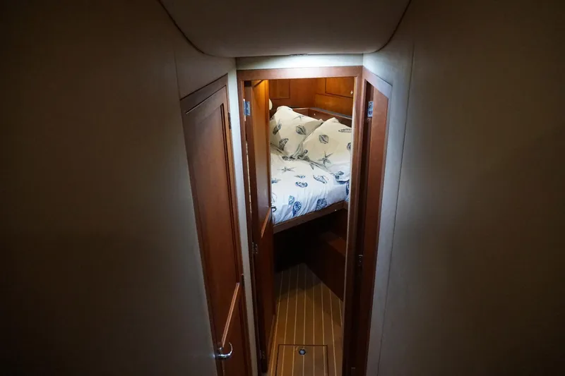 Slide: The Image of Cozy cabin interior of 2005 Mirage Yachts 40 Convertible with wooden doors and nautical bedding. - 20