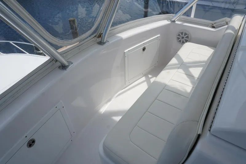 Slide: The Image of 2005 Mirage Yachts 40 Convertible, white seating area with storage, enclosed by clear panels. - 23