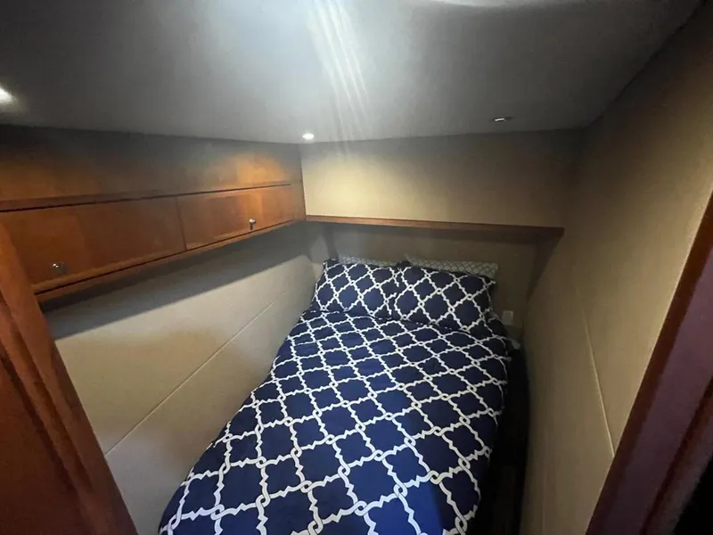 Slide: The Image of Cozy bedroom in 2005 Mirage Yachts 40 Convertible with patterned bedding and wooden cabinets. - 37