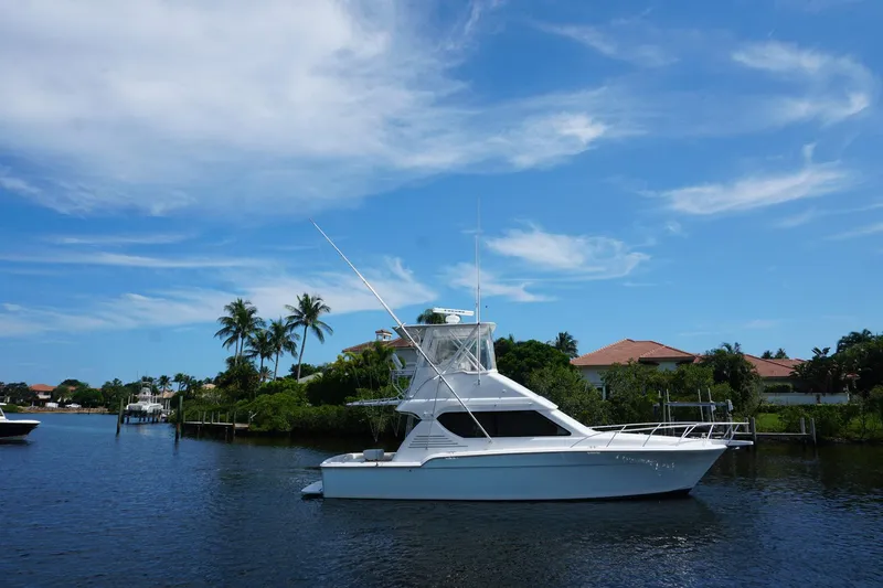 Slide: The Image of 2005 Mirage Yachts 40 Convertible on a serene waterway with blue skies. - 7
