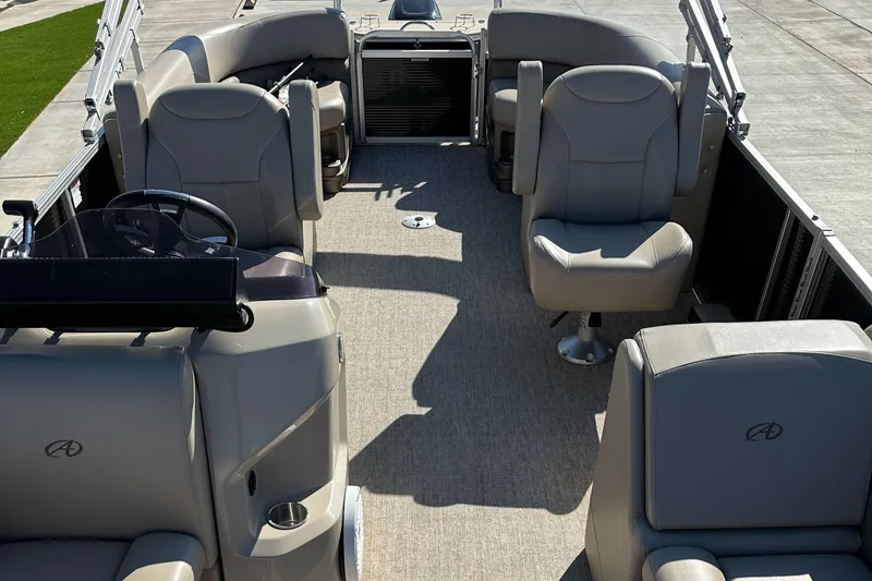 Slide: The Image of 2020 Avalon LSZ 2485 QL pontoon boat interior with plush seating and steering console. - 9
