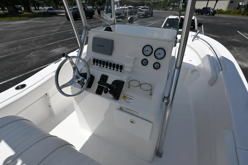Slide: The Image of 2013 Sea Fox 226 Commander boat dashboard with steering wheel and gauges in a parking lot. - 13