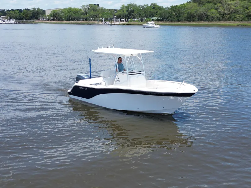 Slide: The Image of 2013 Sea Fox 226 Commander boat cruising on calm water with trees in the background. - 2