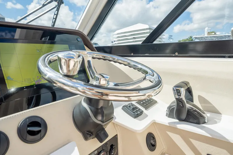 Slide: The Image of Steering wheel and controls of 2022 Regal 36 LX boat, featuring modern navigation display. - 14