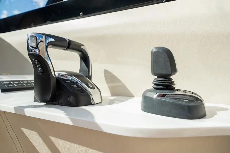 Slide: The Image of 2022 Regal 36 LX boat controls, featuring a sleek throttle and joystick on a white console. - 15