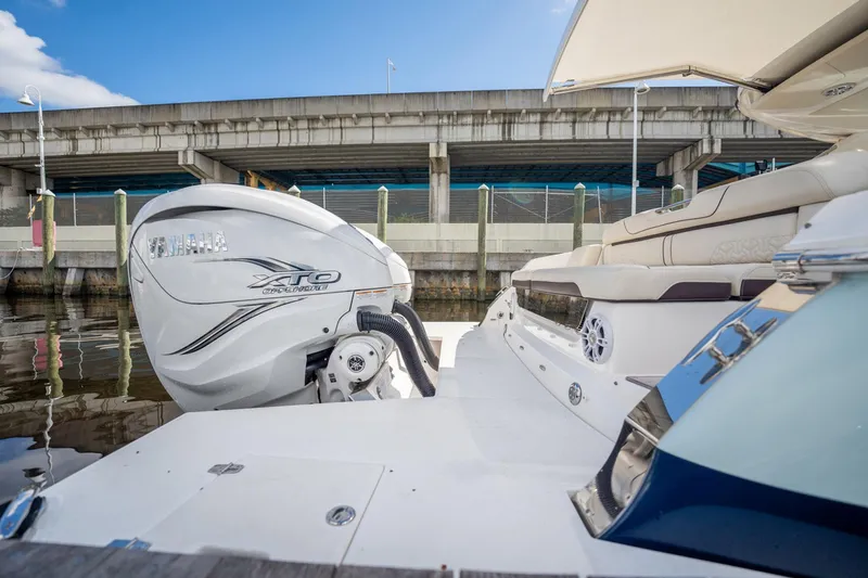 Slide: The Image of 2022 Regal 36 LX boat with powerful outboard engine docked near a bridge. - 28