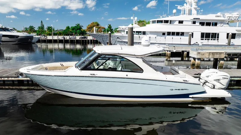 Slide: The Image of 2022 Regal 36 LX boat docked in marina, clear sky, luxury yachts in background. - 30