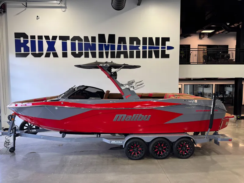 Slide: The Image of 2023 Malibu Wakesetter 26 LSV boat in showroom, red and gray design. - 1