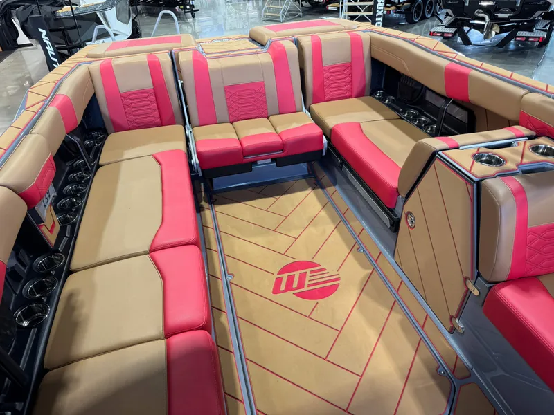 Slide: The Image of 2023 Malibu Wakesetter 26 LSV interior with red and tan seating, cup holders, and logo flooring. - 16