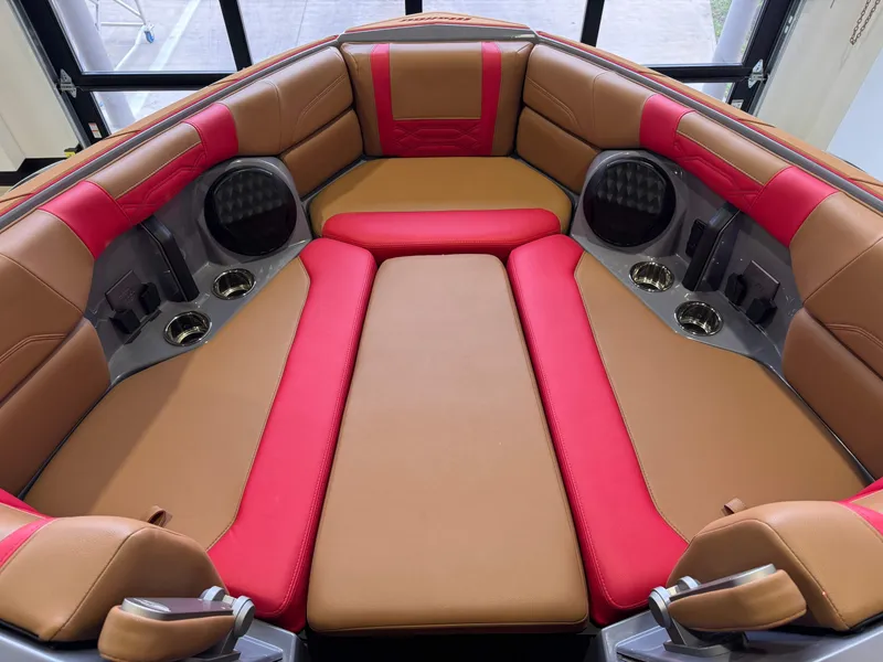 Slide: The Image of 2023 Malibu Wakesetter 26 LSV interior with red and tan seating, cup holders, and speakers. - 17