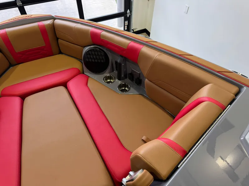 Slide: The Image of 2023 Malibu Wakesetter 26 LSV interior with tan and red seating, cup holders, and speaker. - 18