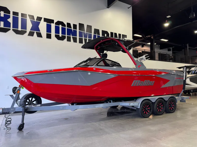 Slide: The Image of 2023 Malibu Wakesetter 26 LSV boat in showroom, red and gray design, on trailer. - 3