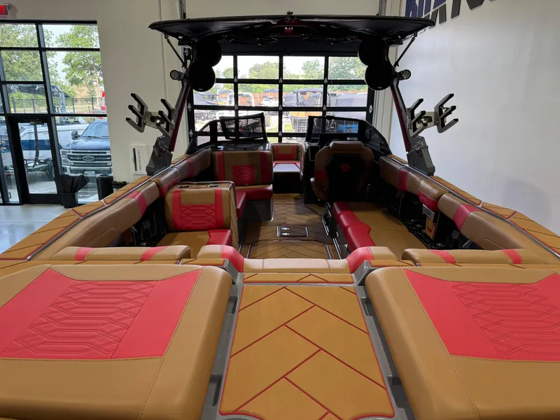 Slide: The Image of 2023 Malibu Wakesetter 26 LSV interior with tan and red seating, spacious layout. - 9