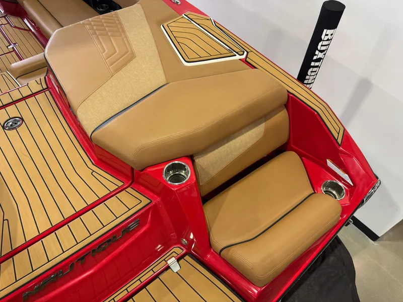 Slide: The Image of 2024 Nautique Super Air Nautique G25 boat interior with tan seats and red accents. - 10