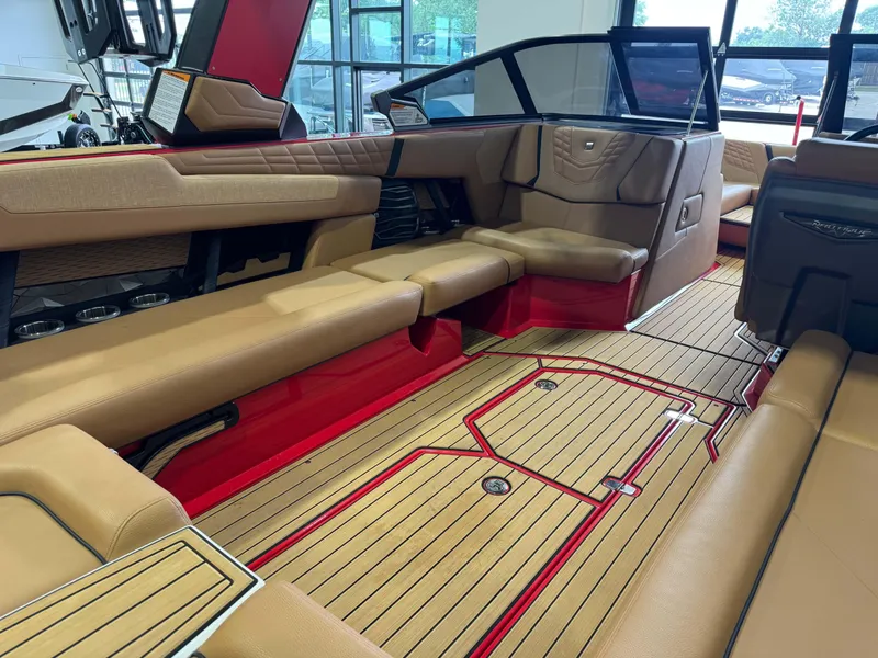 Slide: The Image of 2024 Nautique Super Air Nautique G25 interior with tan seating and red accents. - 13