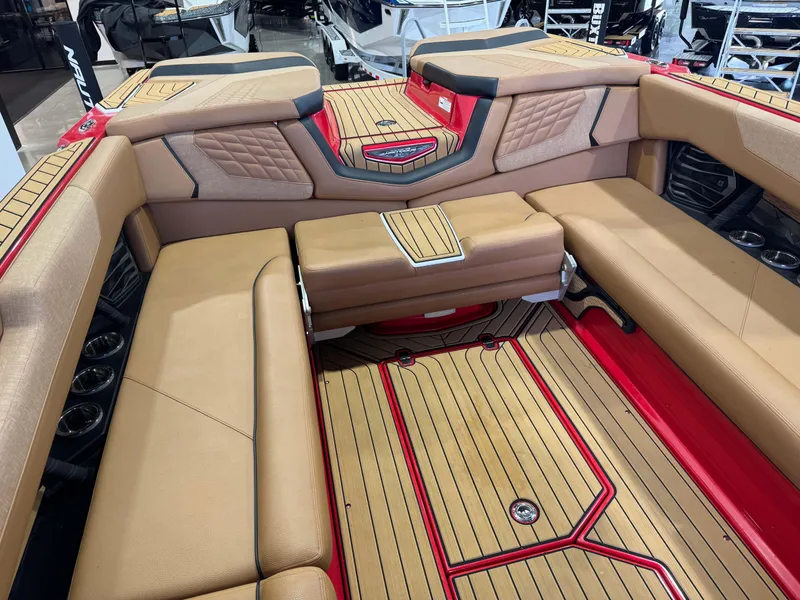 Slide: The Image of 2024 Nautique Super Air Nautique G25 interior with tan seating and red accents. - 15