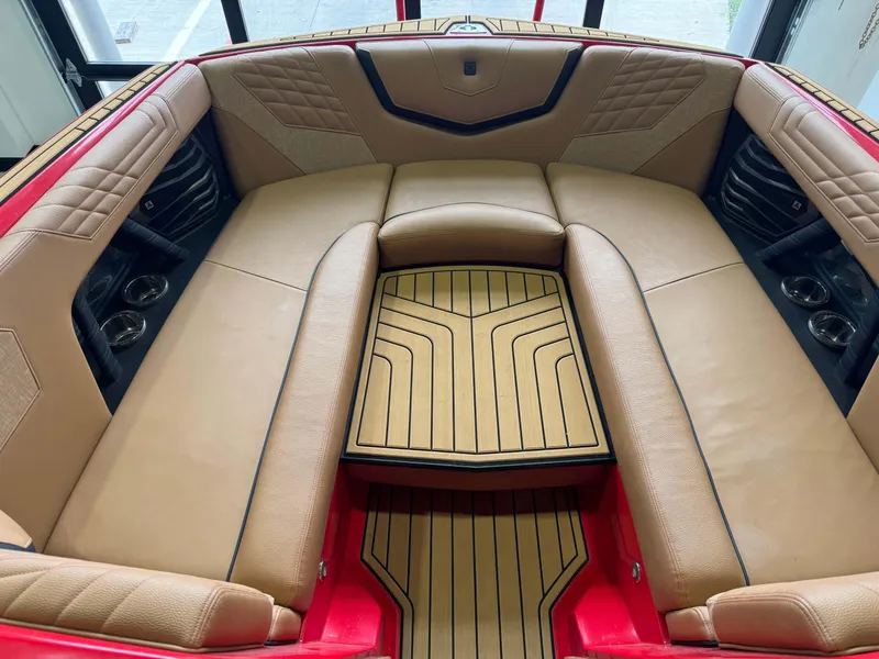 Slide: The Image of 2024 Nautique Super Air Nautique G25 interior with tan leather seating and wood accents. - 16