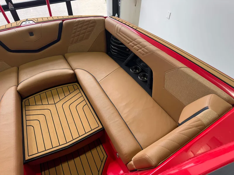 Slide: The Image of 2024 Nautique Super Air Nautique G25 interior with tan upholstery and red accents. - 17