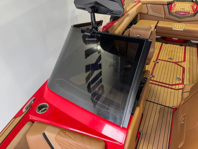 Slide: The Image of 2024 Nautique Super Air Nautique G25 interior with red accents and tan seating. - 19