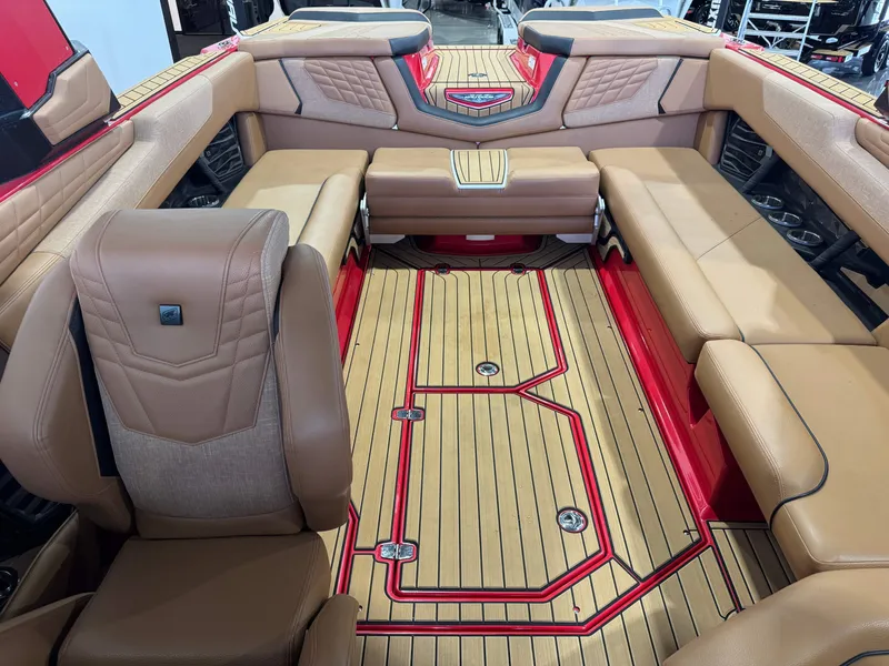 Slide: The Image of 2024 Nautique Super Air Nautique G25 interior with tan seating and red accents. - 21