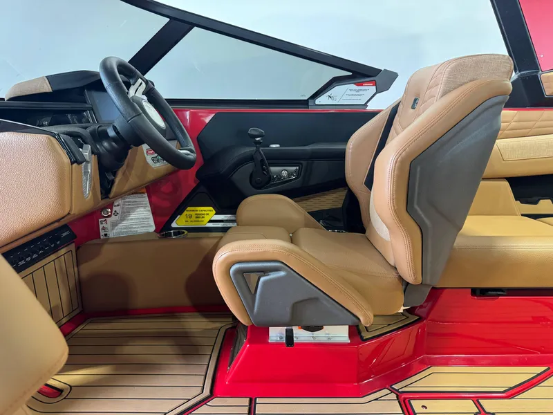 Slide: The Image of 2024 Nautique Super Air Nautique G25 interior with tan seats and red accents. - 22