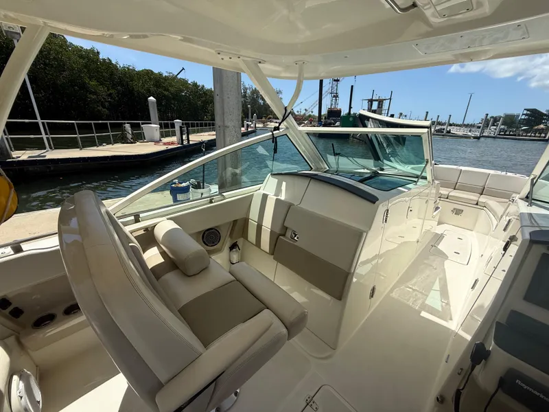 Slide: The Image of 2017 Boston Whaler 320 Vantage boat interior at marina, featuring helm and seating area. - 14
