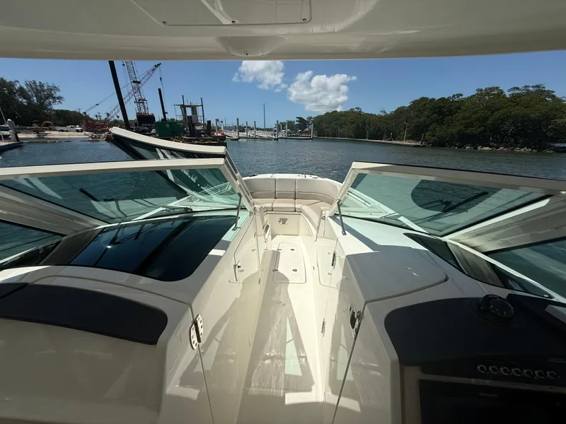 Slide: The Image of 2017 Boston Whaler 320 Vantage boat interior with open deck, docked near a scenic waterfront. - 18