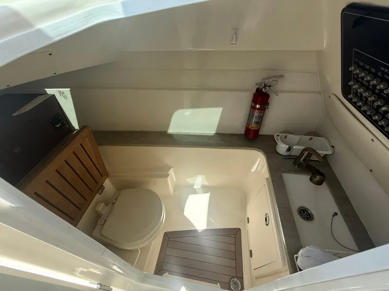 Slide: The Image of 2017 Boston Whaler 320 Vantage boat interior with toilet, sink, and fire extinguisher. - 19