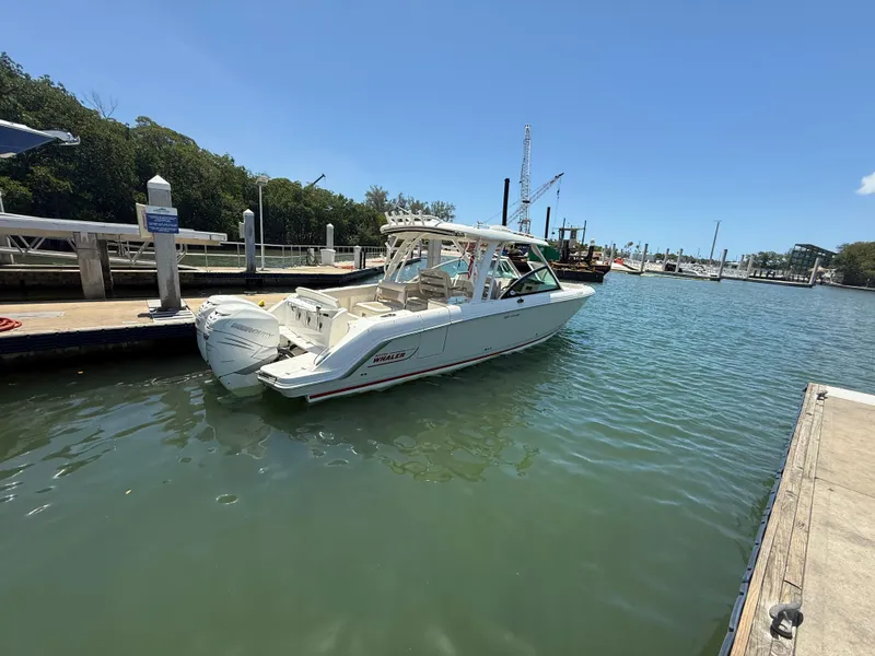 Slide: The Image of 2017 Boston Whaler 320 Vantage docked in a marina under clear blue skies. - 2