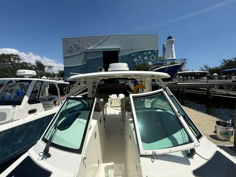 Slide: The Image of 2017 Boston Whaler 320 Vantage docked near a marina with a lighthouse. - 22