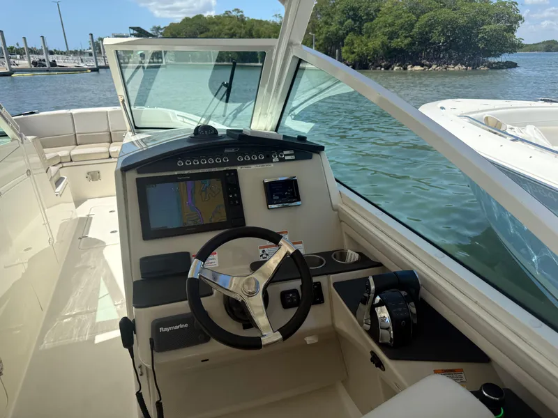 Slide: The Image of 2017 Boston Whaler 320 Vantage helm with navigation system, docked by scenic waterway. - 7