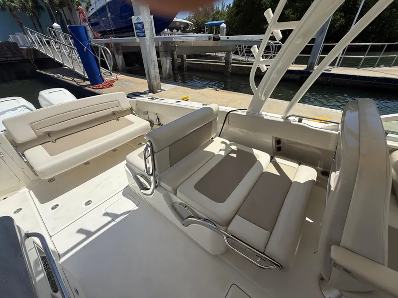 Slide: The Image of 2017 Boston Whaler 320 Vantage boat interior with beige seating at dock. - 9