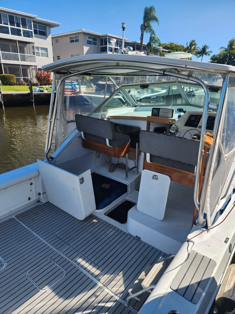Slide: The Image of 1984 Bertram 30 Express boat docked, featuring spacious cockpit and modern helm. - 11