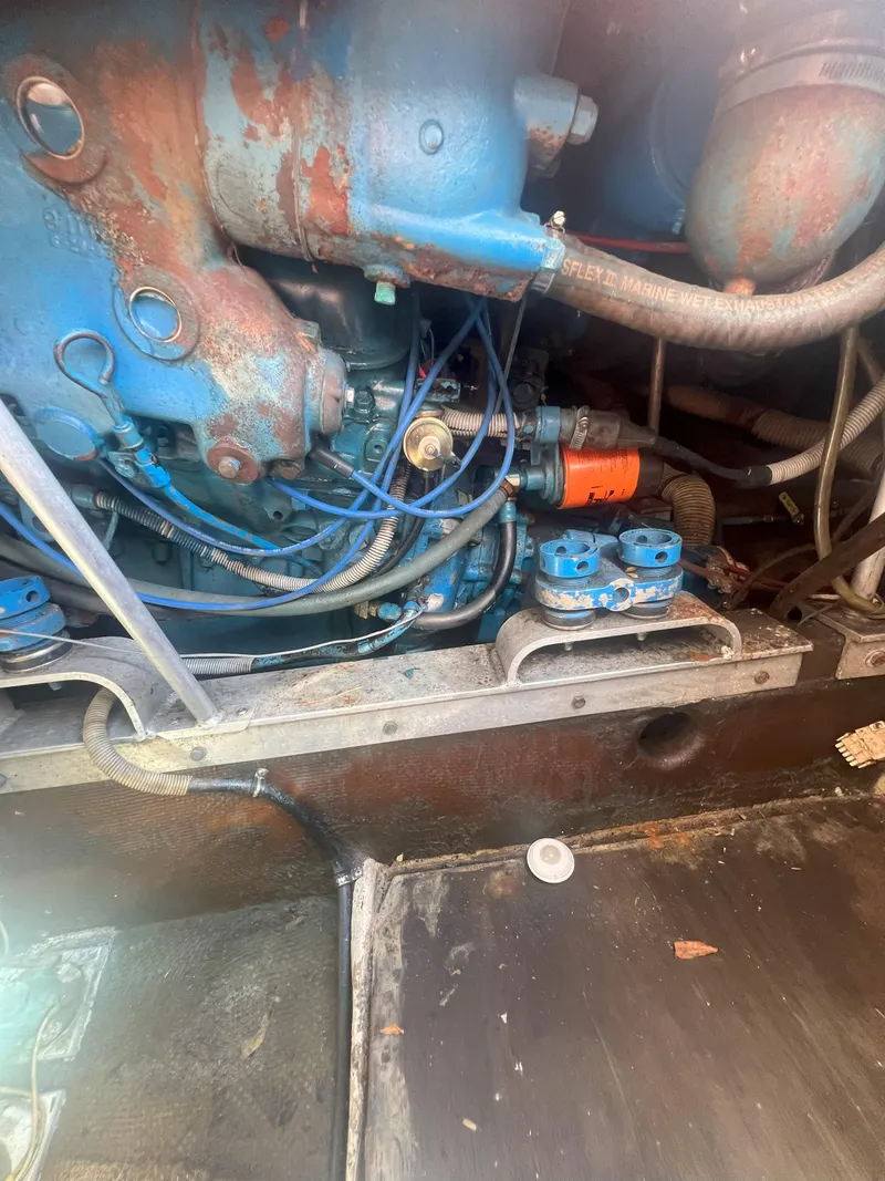 Slide: The Image of Engine compartment of a 1984 Bertram 30 Express boat, showing blue and rusted components. - 16