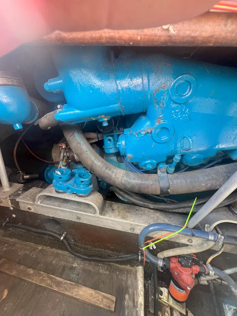 Slide: The Image of Engine compartment of a 1984 Bertram 30 Express boat, featuring blue machinery and hoses. - 17