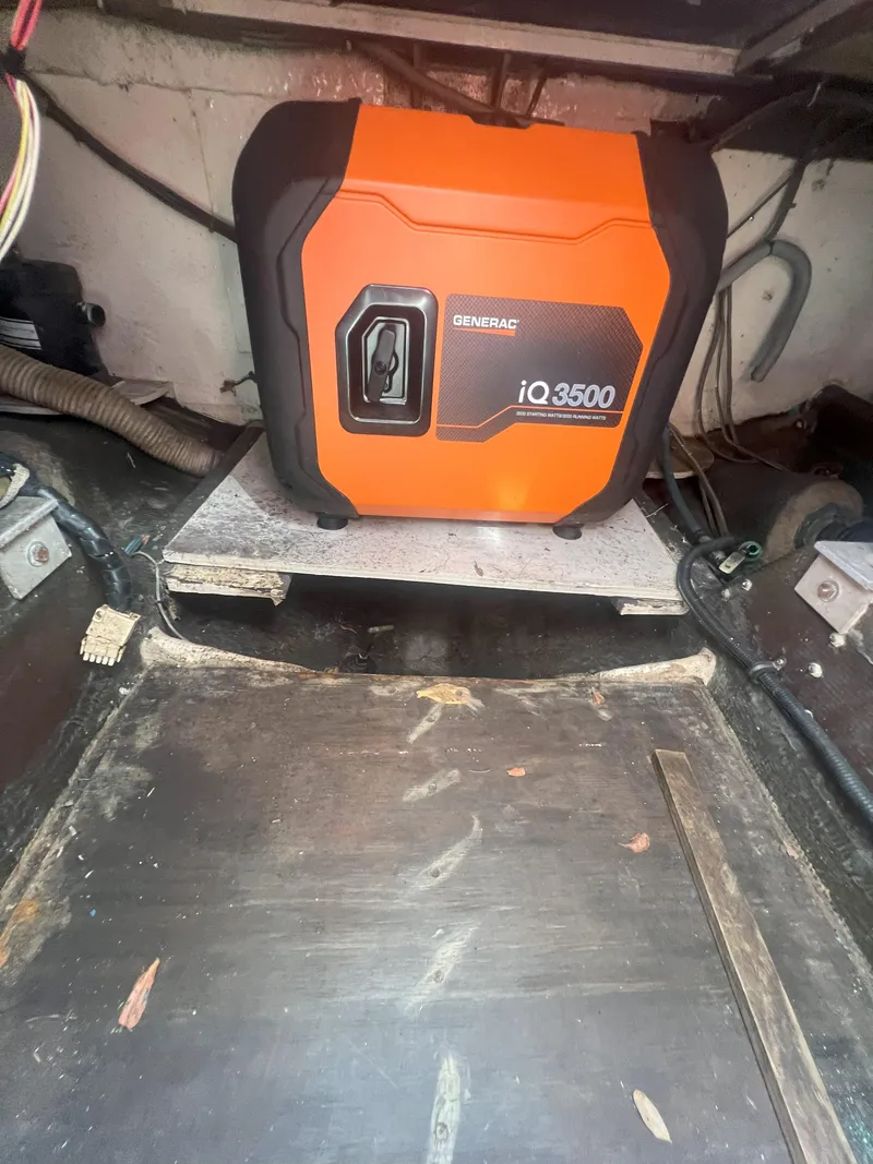 Slide: The Image of Orange Generac iQ3500 generator in a 1984 Bertram 30 Express boat interior. - 18