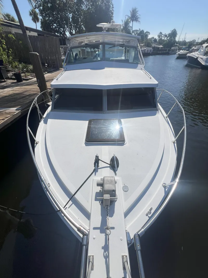 Slide: The Image of 1984 Bertram 30 Express boat docked in a sunny marina. - 19