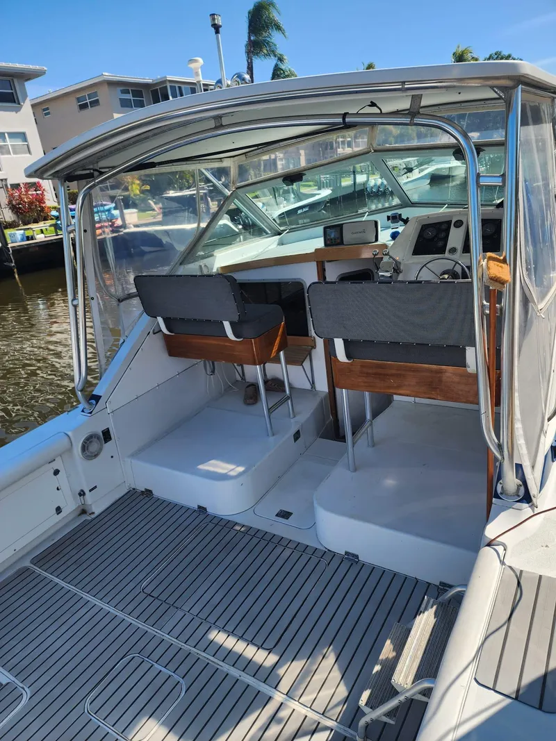 Slide: The Image of 1984 Bertram 30 Express boat interior with helm, seating, and dockside view. - 9