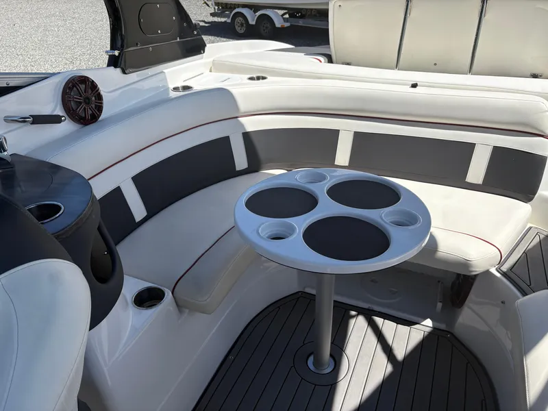 Slide: The Image of 2018 Rinker 26QX BR boat interior with seating and cup holder table. - 13