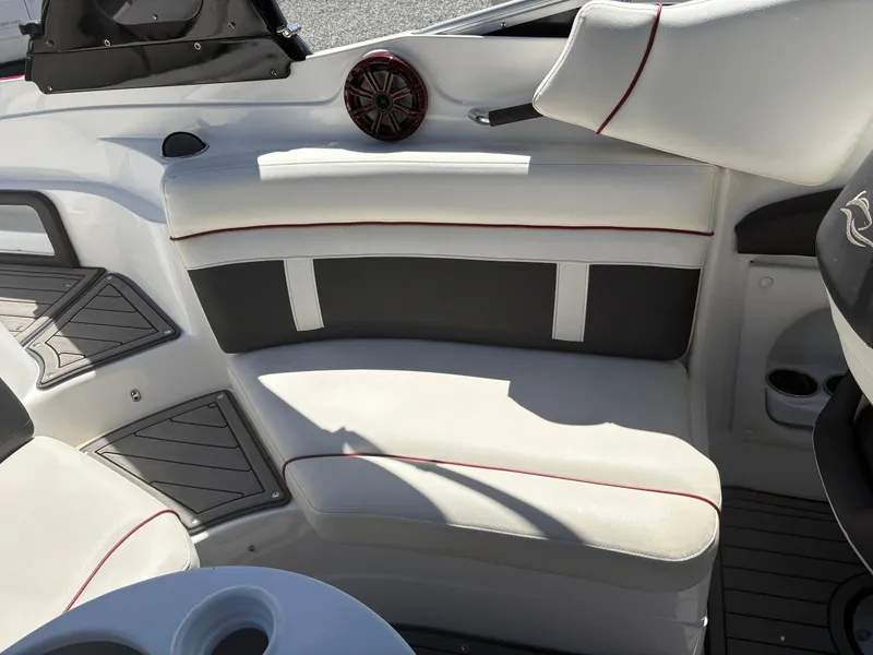 Slide: The Image of 2018 Rinker 26QX BR boat interior with white and black seating, red accents, and cup holders. - 14