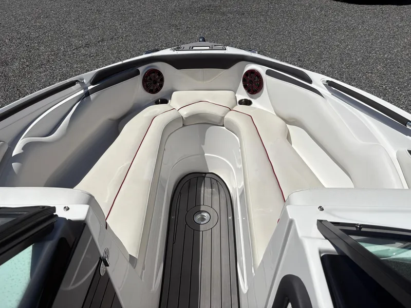 Slide: The Image of 2018 Rinker 26QX BR boat interior with white seating and wood flooring. - 28